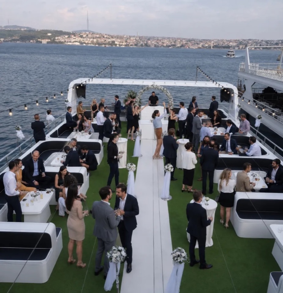 Guests mingling at a cocktail reception on the upper deck of a passenger vessel